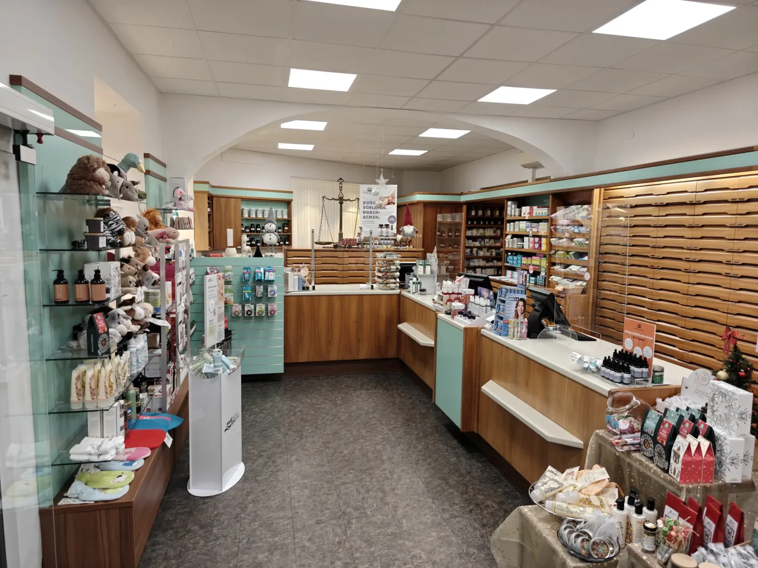 Verkaufsraum der Museum-Apotheke mit Holztheke, historischer Apothekerwaage und Schubladenwand