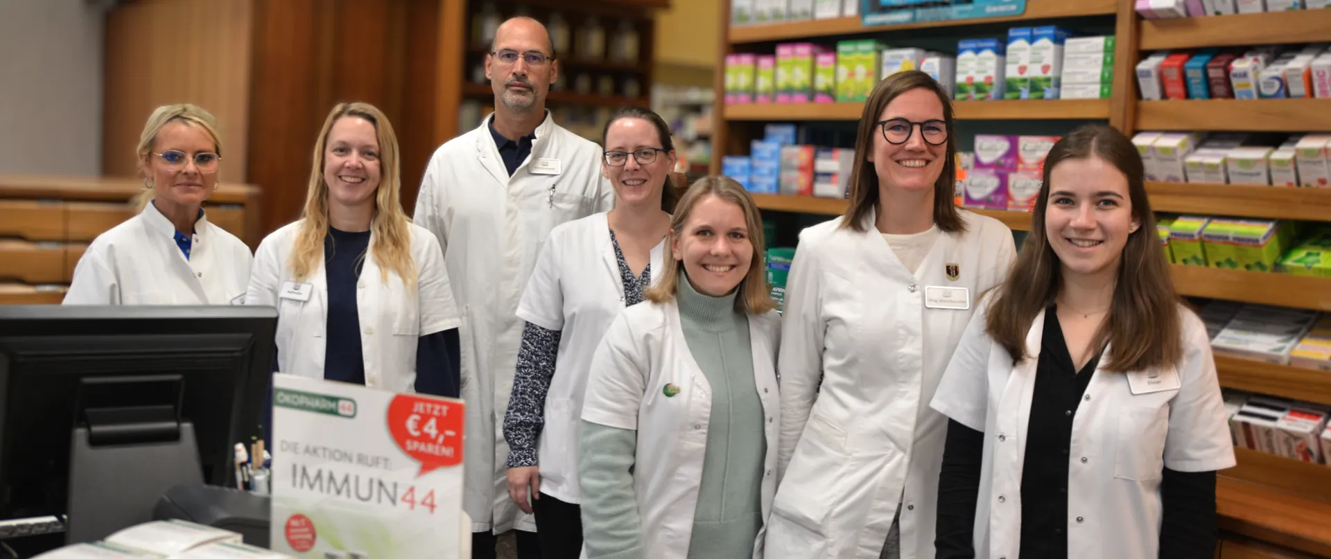 Das Team der Museum-Apotheke in weißen Mänteln vor der Verkaufstheke